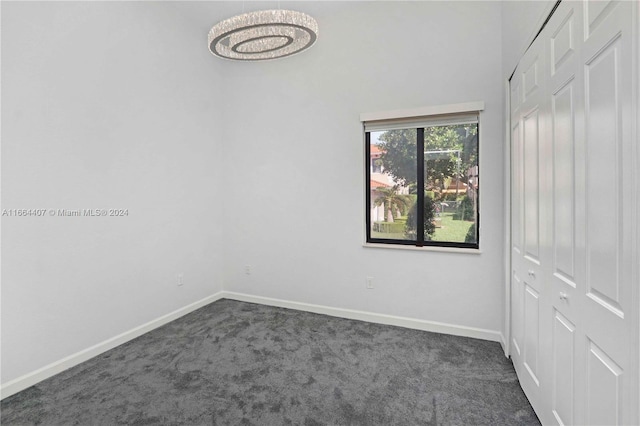 spare room featuring dark colored carpet