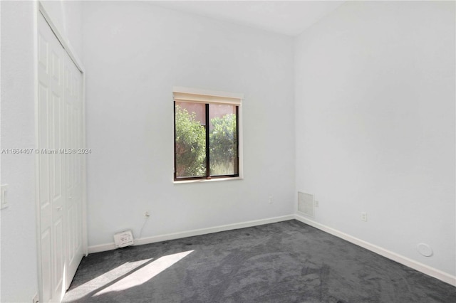 empty room featuring dark colored carpet