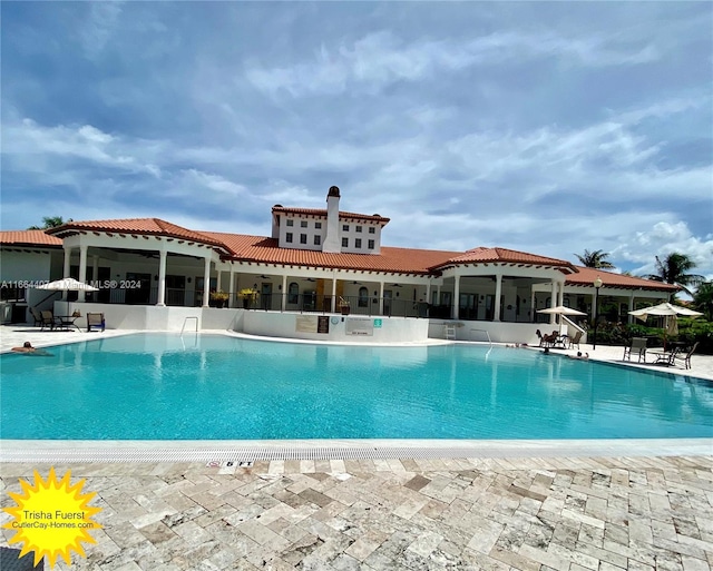 view of pool with a sunroom and a patio area