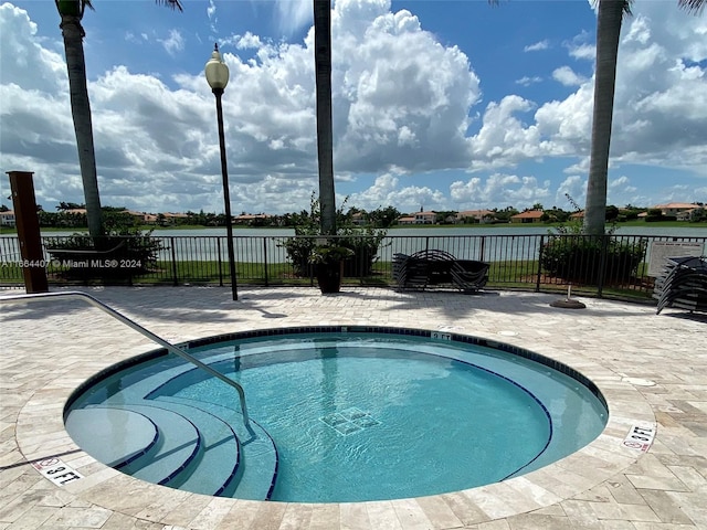 view of pool with a patio and a water view