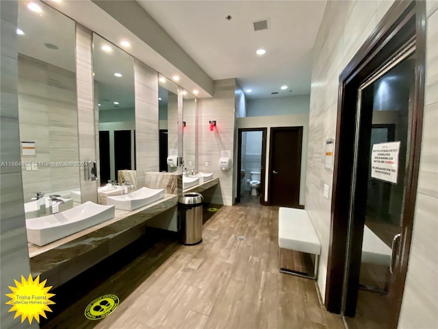 bathroom with tile walls, vanity, and hardwood / wood-style flooring