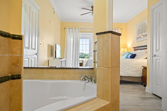 bathroom with ornamental molding, ceiling fan, hardwood / wood-style flooring, and a bathing tub