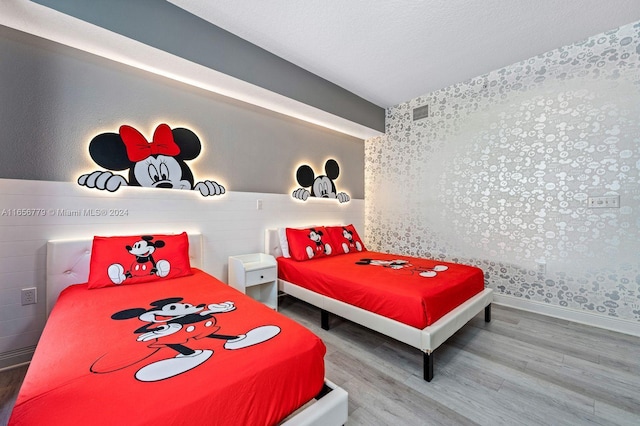 bedroom with a textured ceiling and hardwood / wood-style flooring