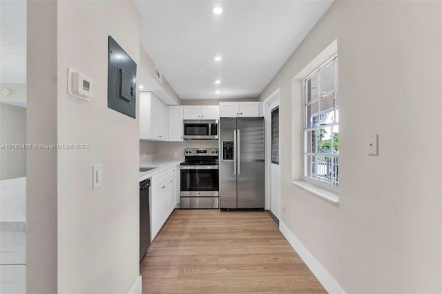 kitchen featuring appliances with stainless steel finishes, light hardwood / wood-style floors, and white cabinets