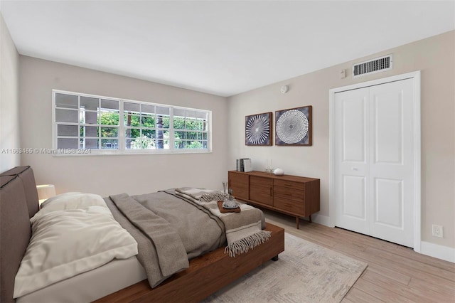 bedroom with light wood-type flooring and a closet