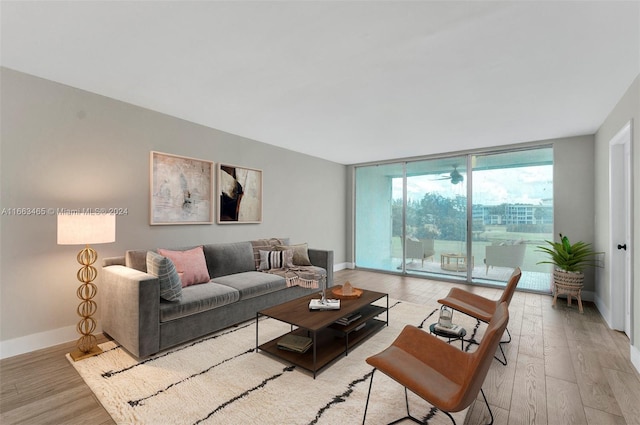 living room featuring light wood-type flooring and floor to ceiling windows