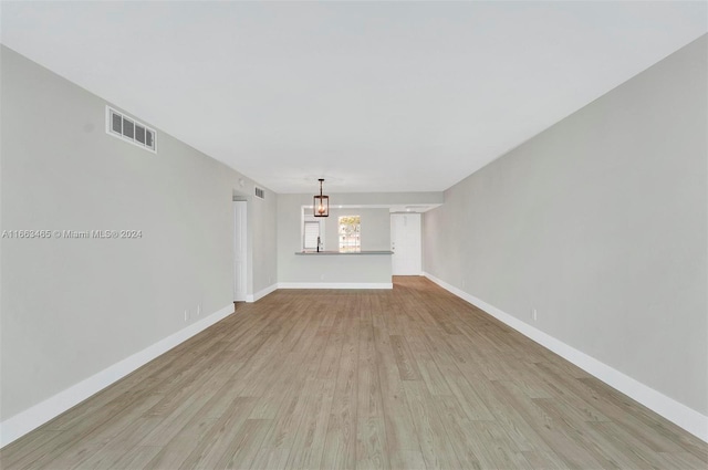 unfurnished living room featuring light hardwood / wood-style floors and sink