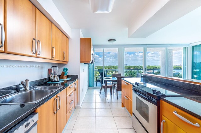 kitchen featuring sink, light tile patterned floors, range with electric cooktop, dishwasher, and dark stone countertops