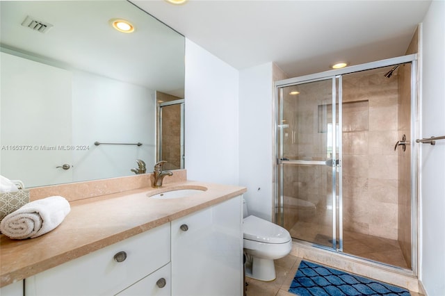 bathroom with vanity, a shower with shower door, toilet, and tile patterned flooring