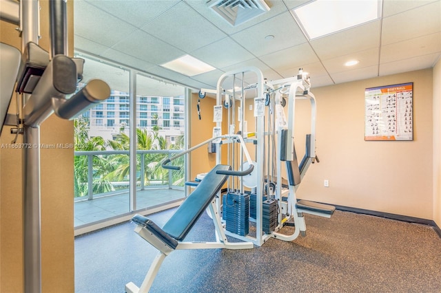 workout area with a paneled ceiling and a healthy amount of sunlight