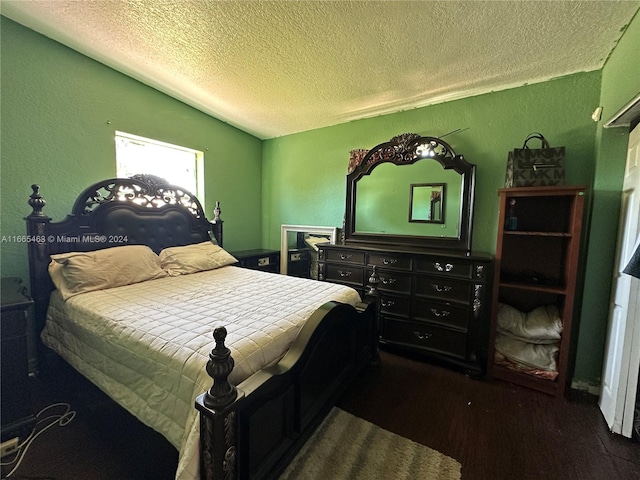 bedroom with a textured ceiling, vaulted ceiling, and dark hardwood / wood-style floors