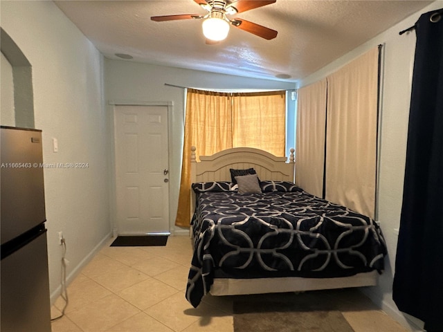 tiled bedroom featuring stainless steel fridge, a textured ceiling, and ceiling fan