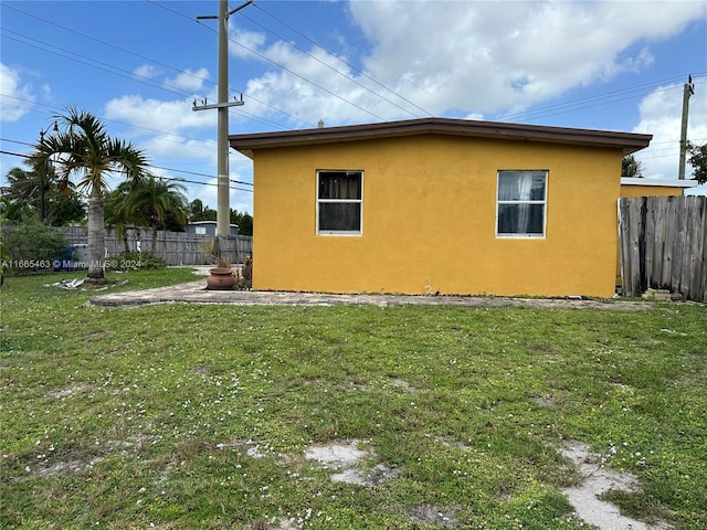 view of side of home with a yard