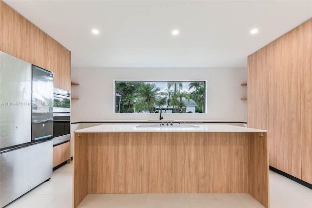 kitchen featuring stainless steel appliances, a center island, and sink