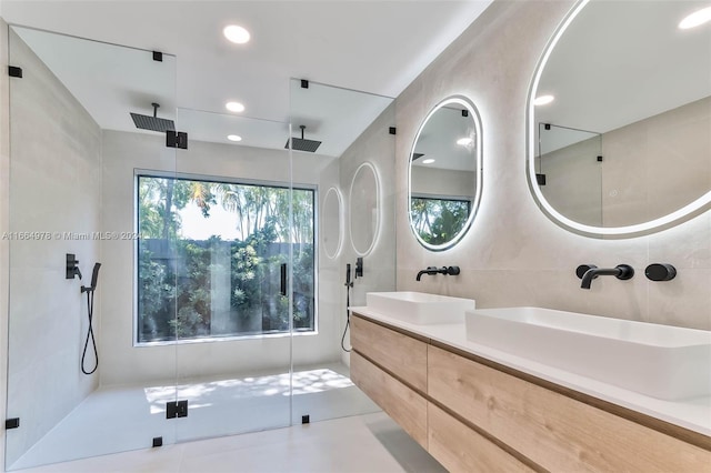 bathroom with tile walls, a shower with door, and vanity