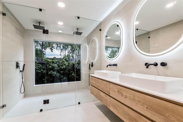 bathroom featuring walk in shower, tile walls, vanity, and tile patterned floors