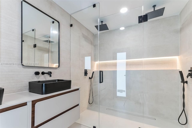 bathroom featuring tile walls, a shower with shower door, and vanity