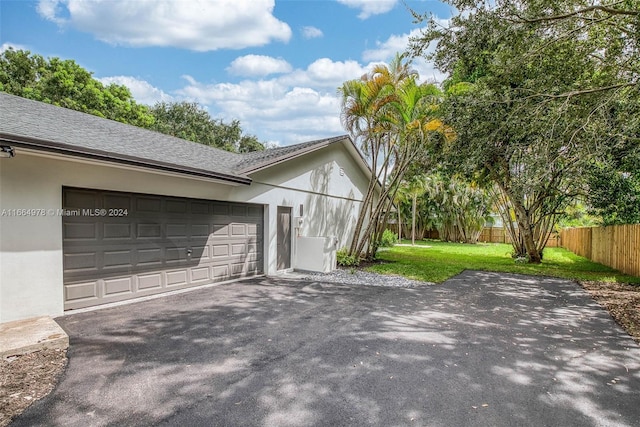 view of side of home with a garage and a yard