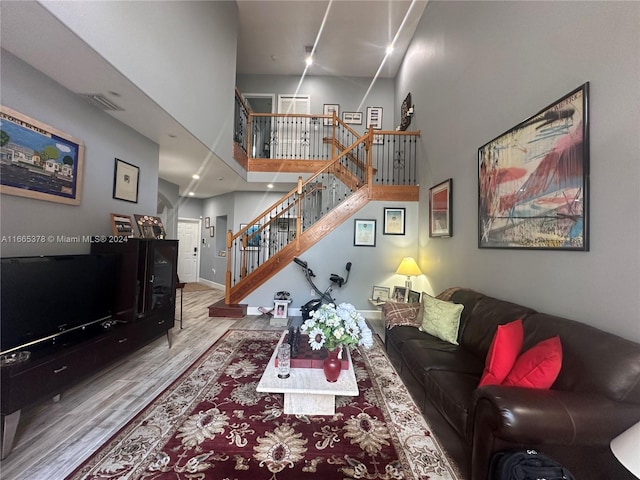 living room featuring a high ceiling and hardwood / wood-style floors