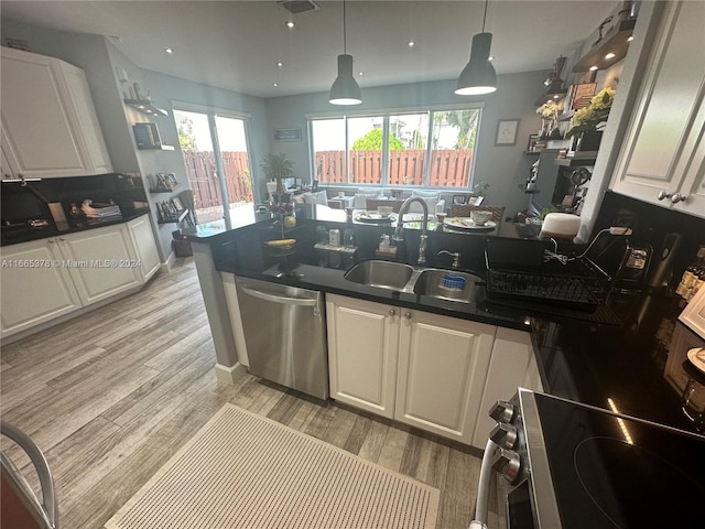 kitchen featuring appliances with stainless steel finishes, white cabinetry, light wood-type flooring, decorative light fixtures, and sink