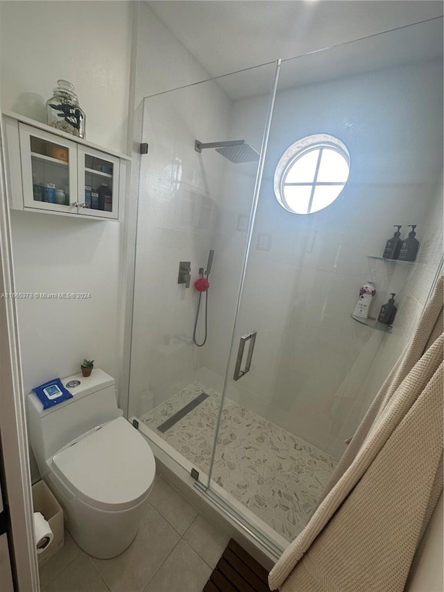 bathroom featuring toilet, an enclosed shower, and tile patterned floors