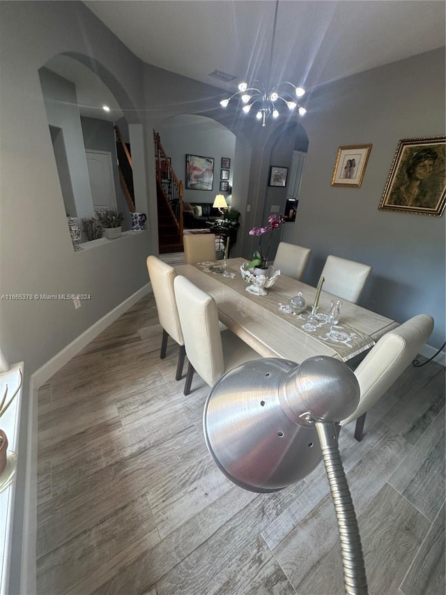 dining room featuring wood-type flooring and a notable chandelier