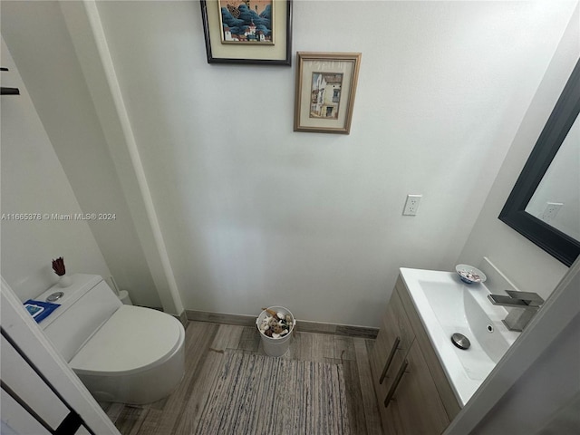 bathroom with hardwood / wood-style floors, vanity, and toilet