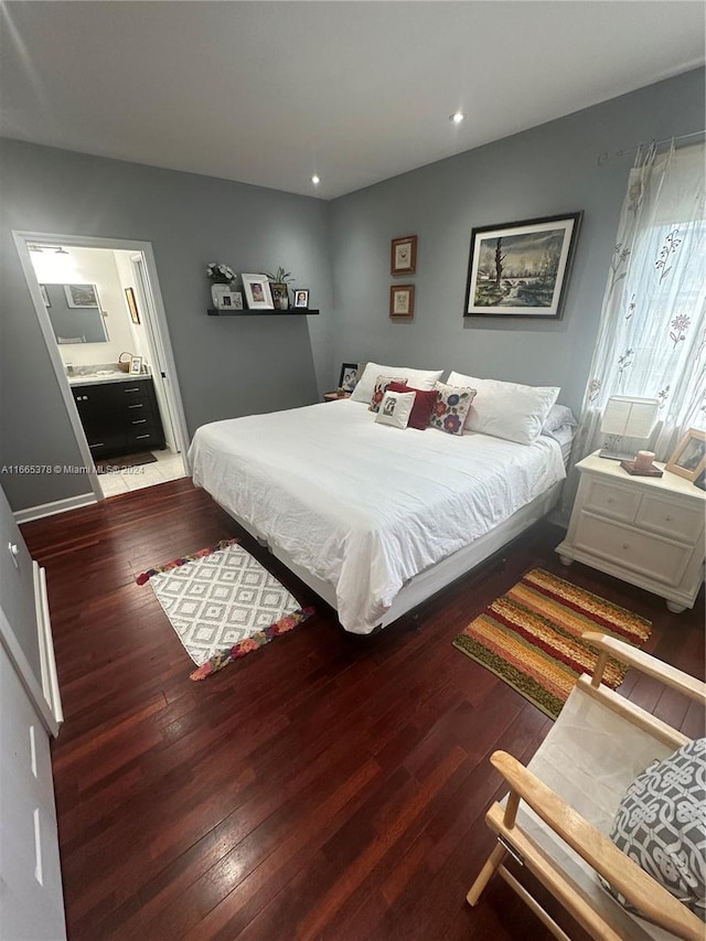 bedroom with ensuite bath and hardwood / wood-style flooring