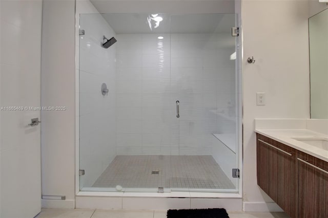 bathroom with tile patterned floors, vanity, and a shower with door