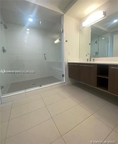 bathroom featuring vanity, tile patterned floors, and a shower with shower door