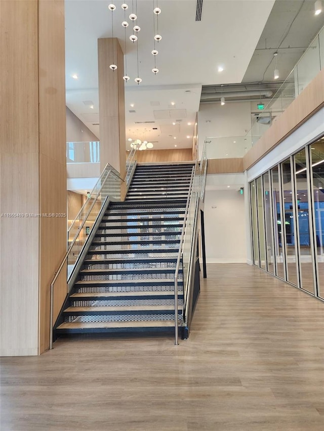 stairs with a high ceiling and hardwood / wood-style floors