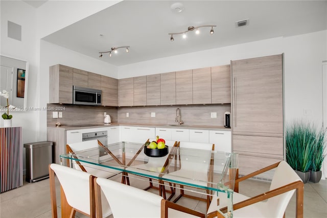 kitchen featuring sink, tasteful backsplash, oven, white cabinetry, and black electric stovetop