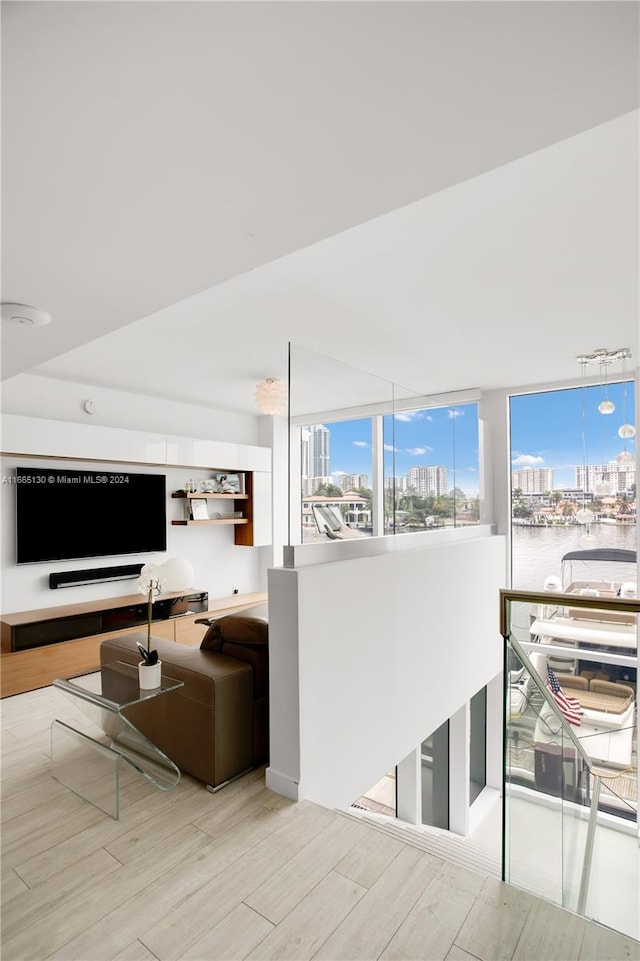 living room with a water view and light hardwood / wood-style flooring