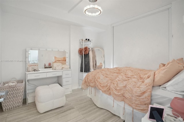 bedroom with light hardwood / wood-style floors and a notable chandelier