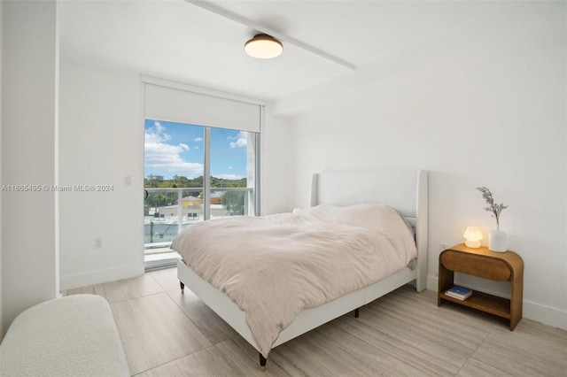 bedroom with light wood-type flooring and access to exterior