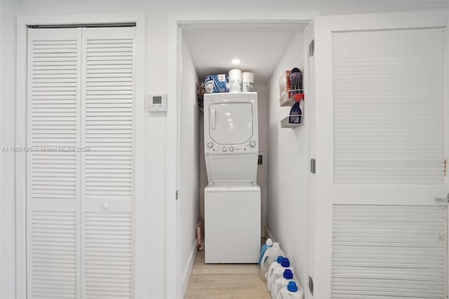 laundry area featuring light hardwood / wood-style flooring and stacked washer / drying machine