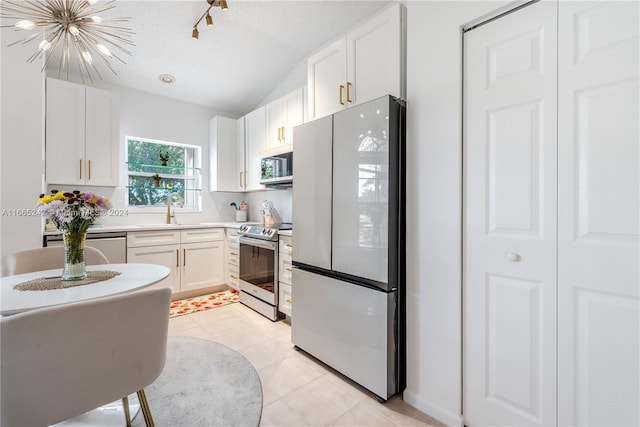 kitchen featuring stainless steel appliances, white cabinetry, a textured ceiling, and light tile patterned floors