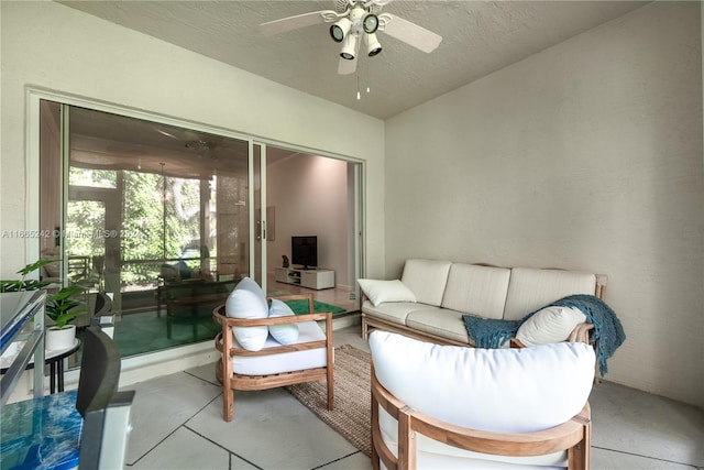 living room with a textured ceiling and ceiling fan