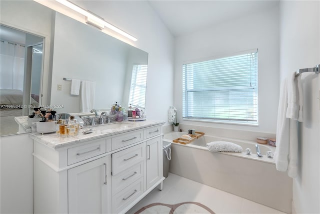 bathroom with tile patterned flooring, a tub to relax in, plenty of natural light, and vanity