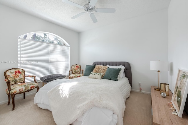 bedroom with a textured ceiling, light carpet, and ceiling fan