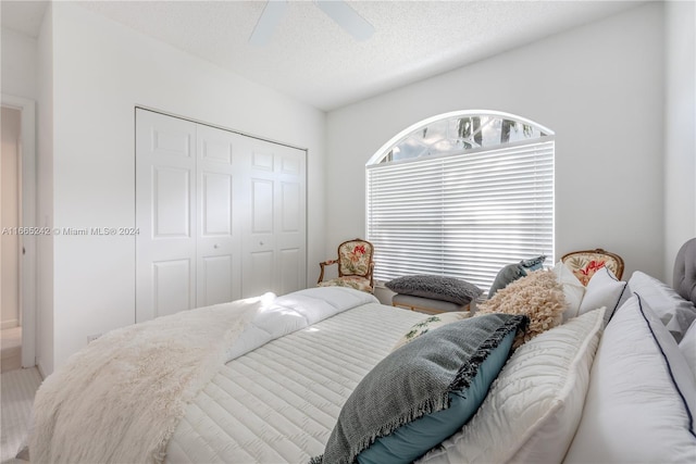 bedroom with a closet, ceiling fan, and a textured ceiling