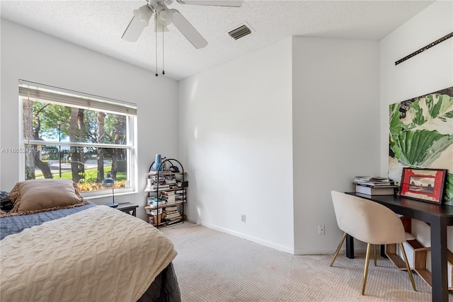 bedroom with a textured ceiling, light carpet, and ceiling fan