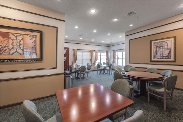 dining room featuring a textured ceiling and carpet floors