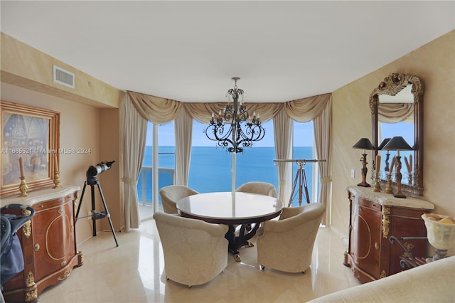 dining space with a notable chandelier and a water view