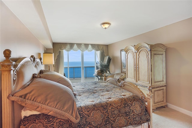 carpeted bedroom featuring a water view and access to outside