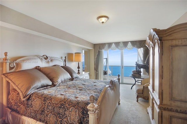 bedroom with a water view, light carpet, and access to exterior