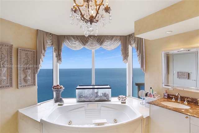 bathroom featuring a notable chandelier, a water view, tiled tub, and vanity