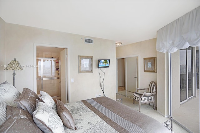 bedroom featuring a closet, light colored carpet, and ensuite bathroom