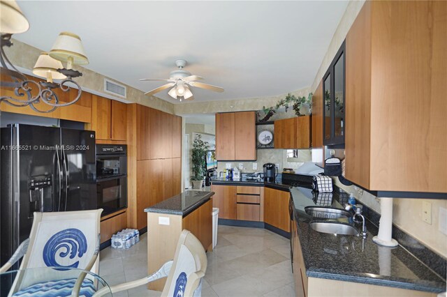 kitchen with ceiling fan, light tile patterned floors, a kitchen island, black appliances, and decorative backsplash