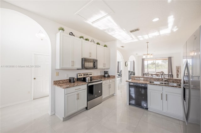 kitchen featuring sink, black appliances, pendant lighting, dark stone countertops, and white cabinetry